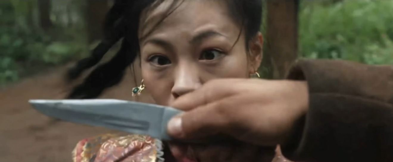 Final screen close-up: the matching knife pass in an outdoor woodland setting.